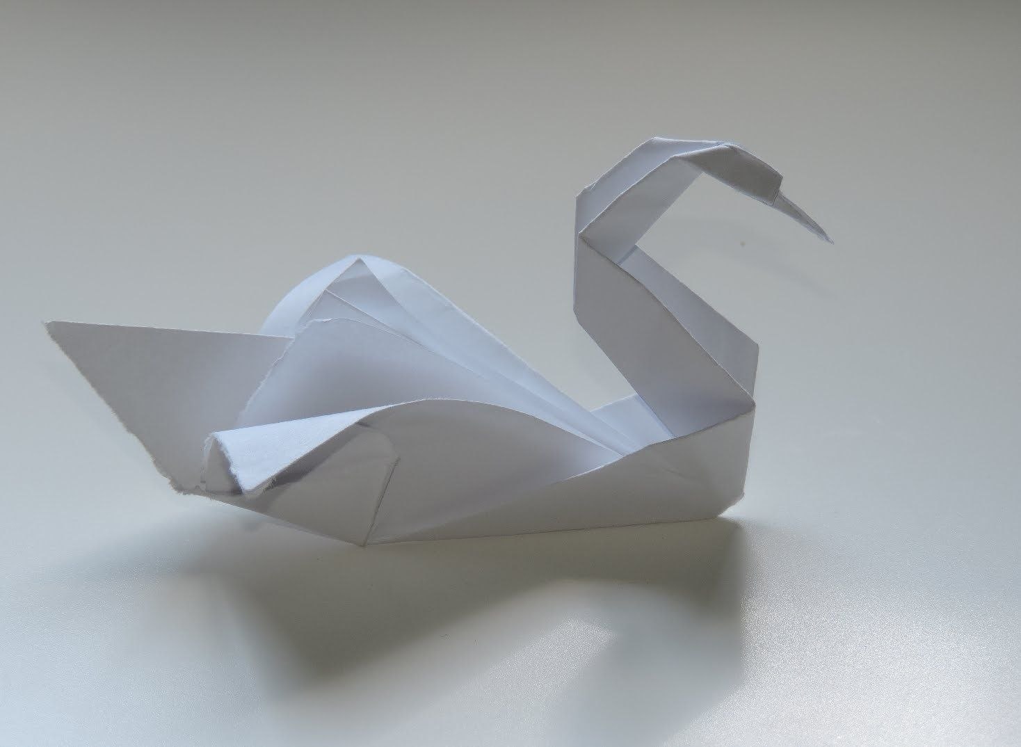 Лебедь из бумаги инструкция. Лебедь шипун оригами. Оригами лебедь из бумаги. Бумажный лебедь оригами. Фигурка лебедя из бумаги.